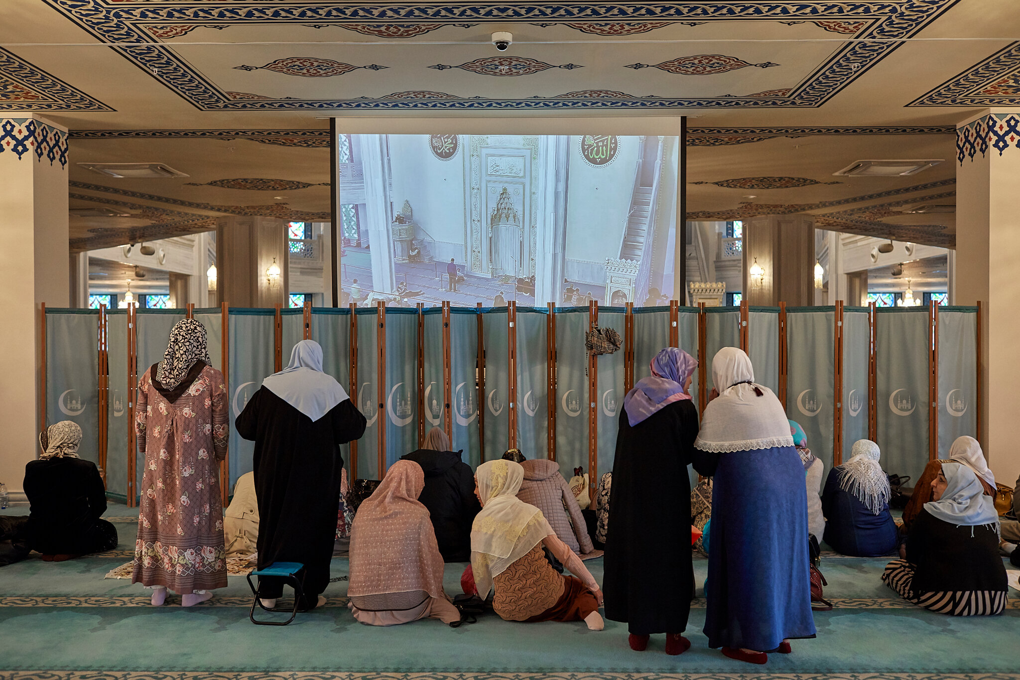  Russia, Moscow, Moscow Cathedral mosque, 04/10/2019. Women are waiting for the Friday prayer to begin. Women and men have separated areas. A big screen is installed so that women can see the imam. The Friday prayer or Jumu'ah is led by a sermon give