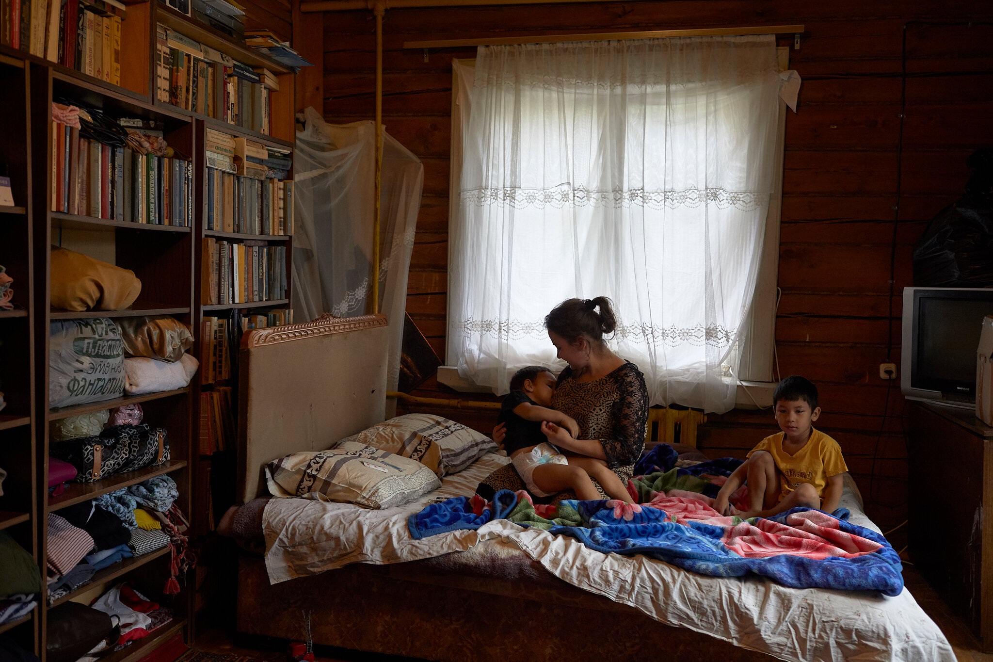 Russia, Moscow oblast, Odintsovo city district, Perhushkovo village, 05/10/2019. Zarina U., 19, takes care of brothers Elyor, five (at right), and Elnur, three, in a village outside Moscow. Zarina’s mother and the boys’ grandmother, friends back in
