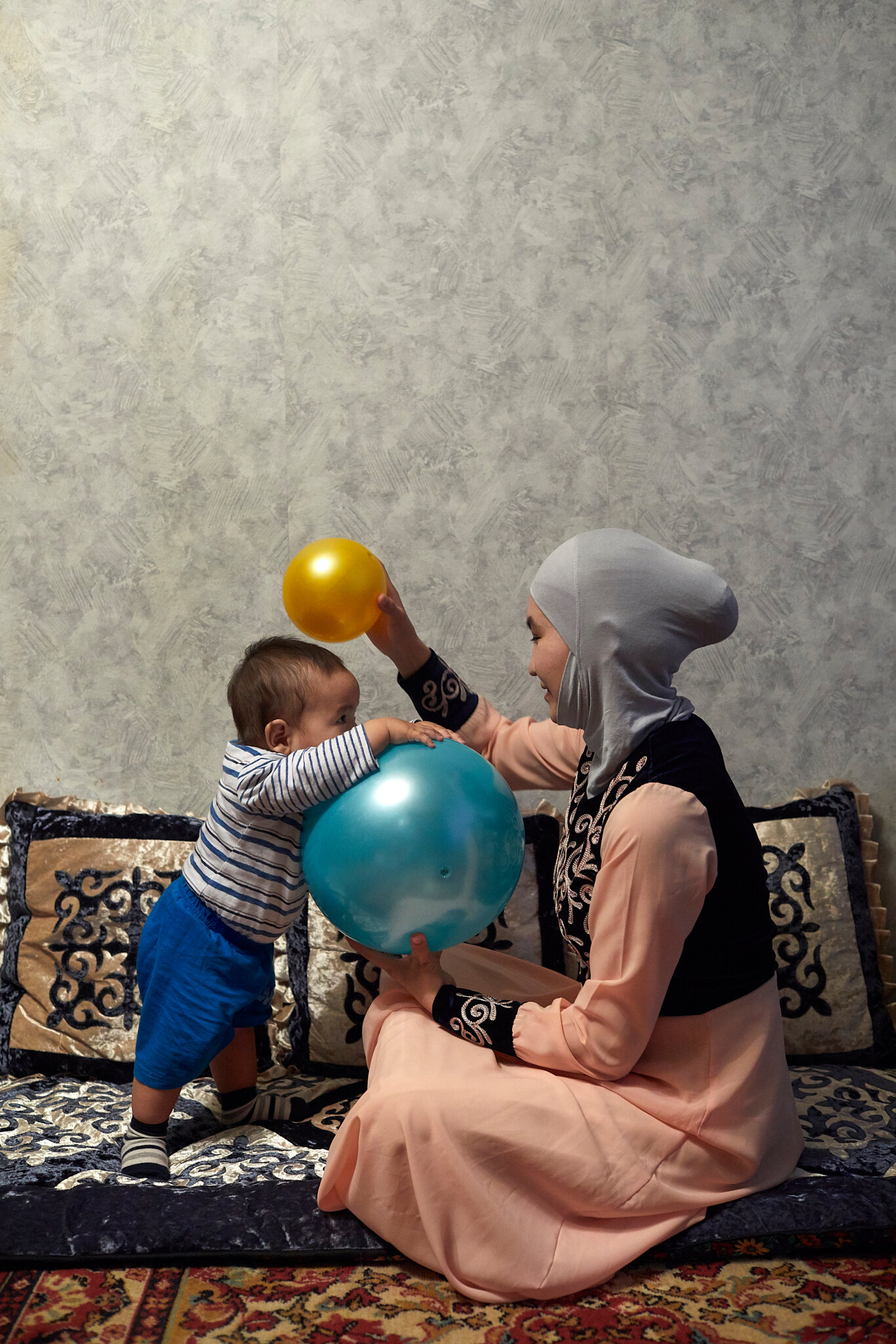 Russia, Moscow, 07/10/2019. Shahrizada plays with eight-month-old Kagan. She started the Aiymdar KG organization to help other Kyrgyz women in Moscow navigate life in Russia and to provide a safe space to talk about relationships and family matters.