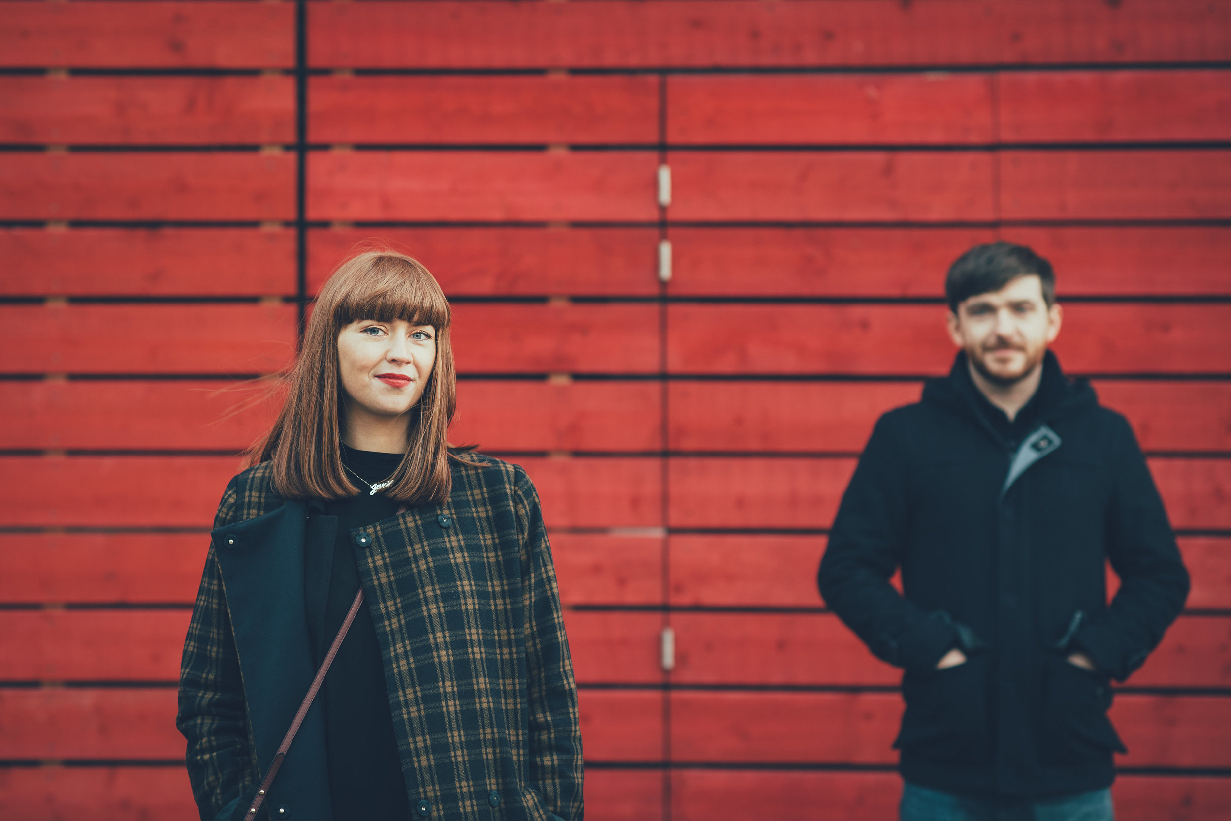 Couple in front of red wall at the National Theatre London