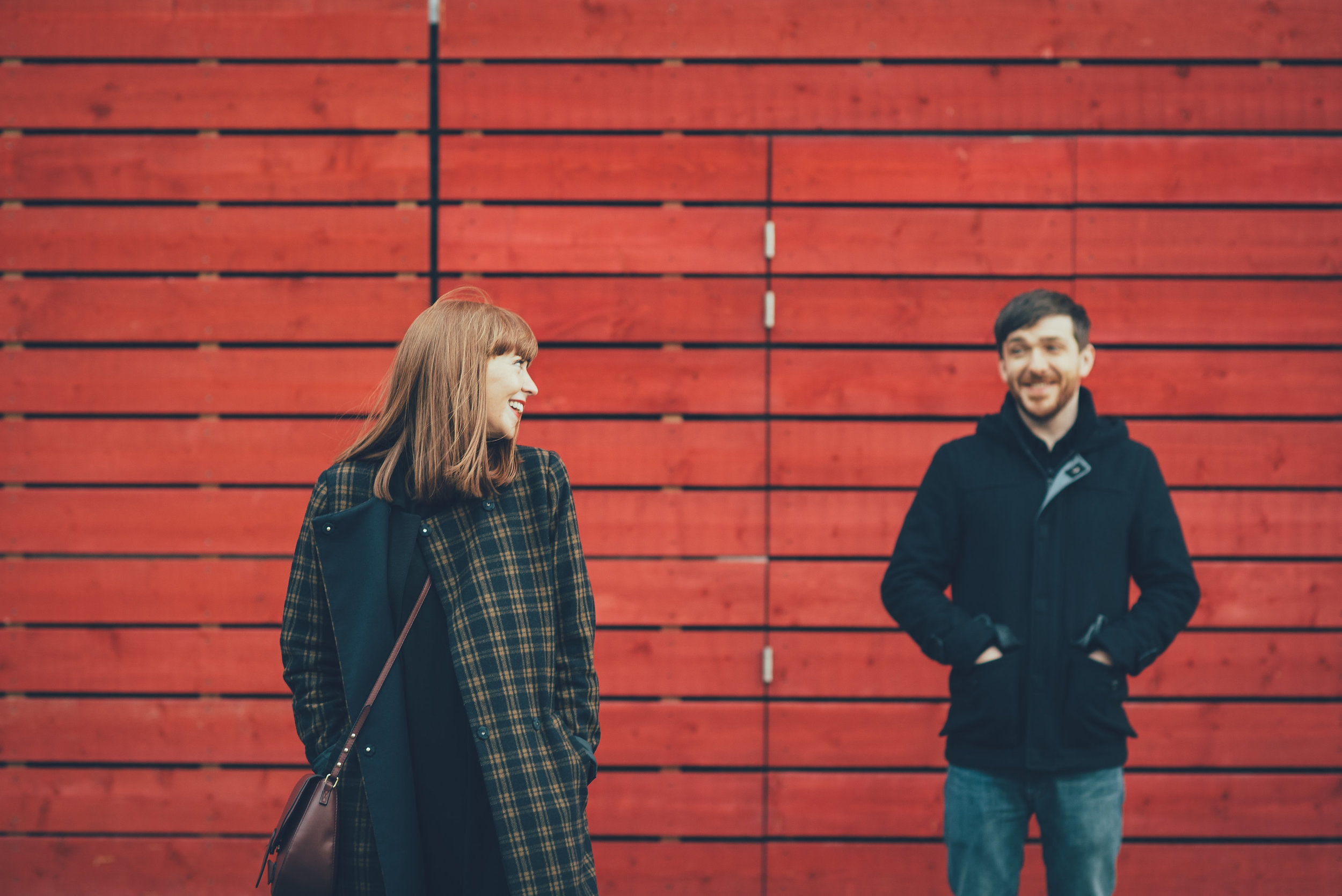 Couple in front of red wall at the National Theatre London