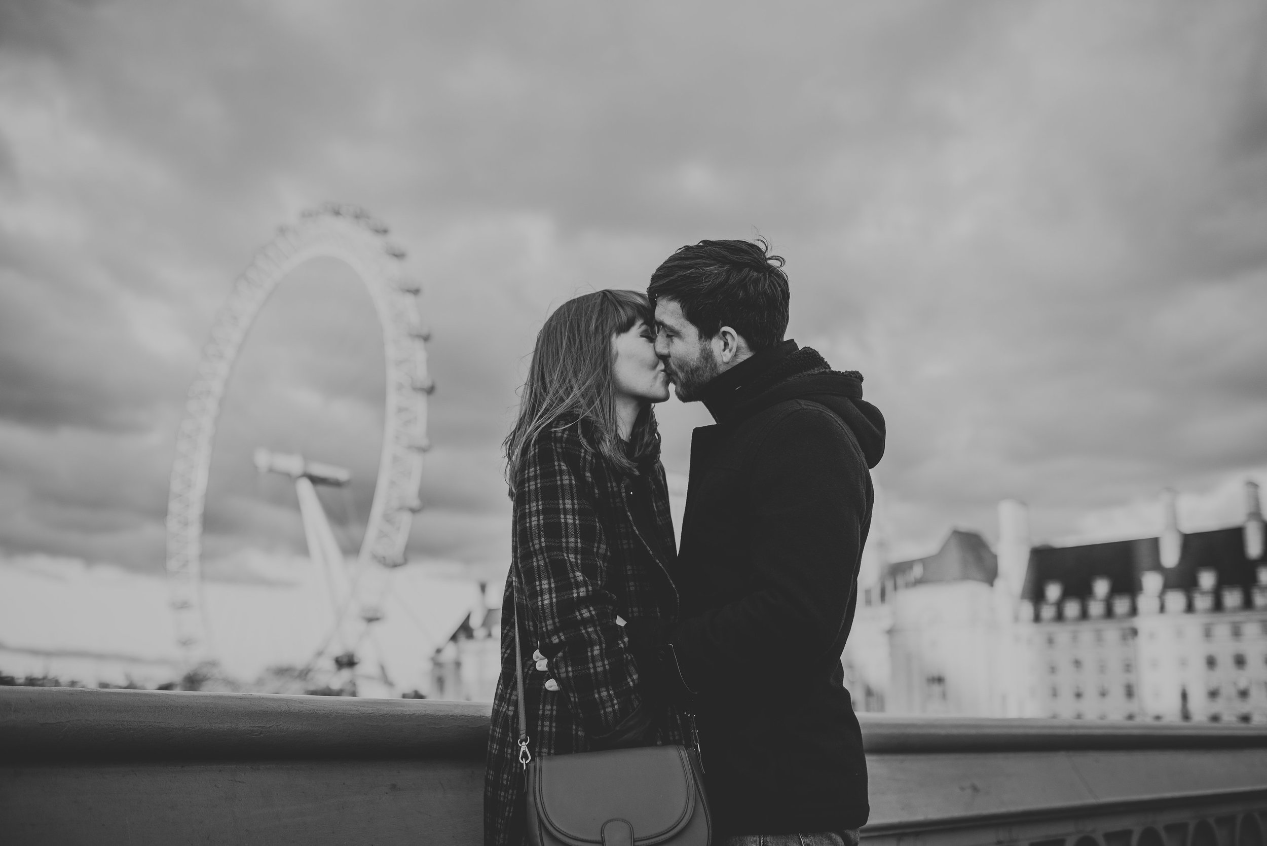 Engaged couple in love kissing in front of London Eye