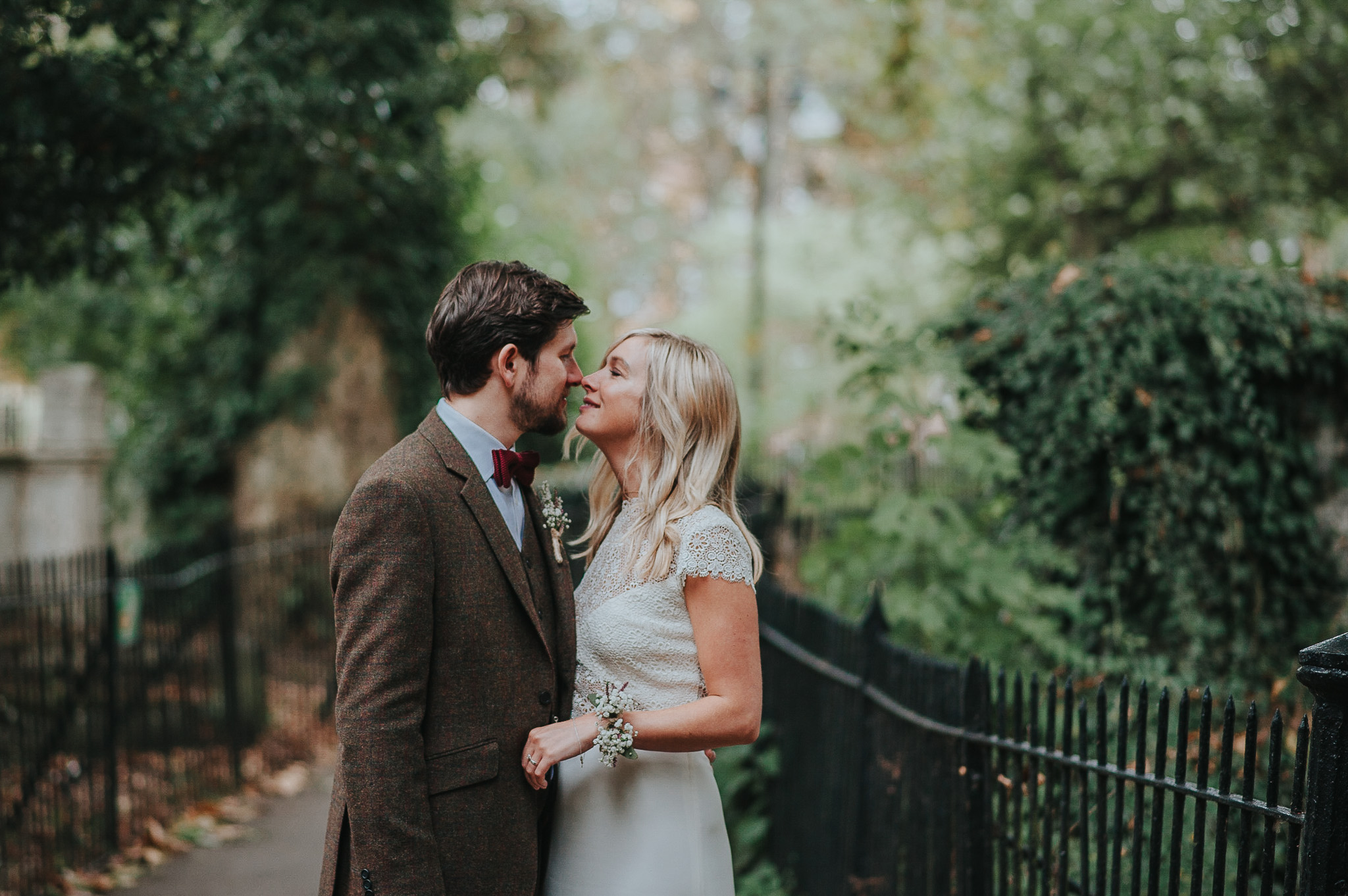 Bride and groom kissing in Clissold Park after wedding ceremony