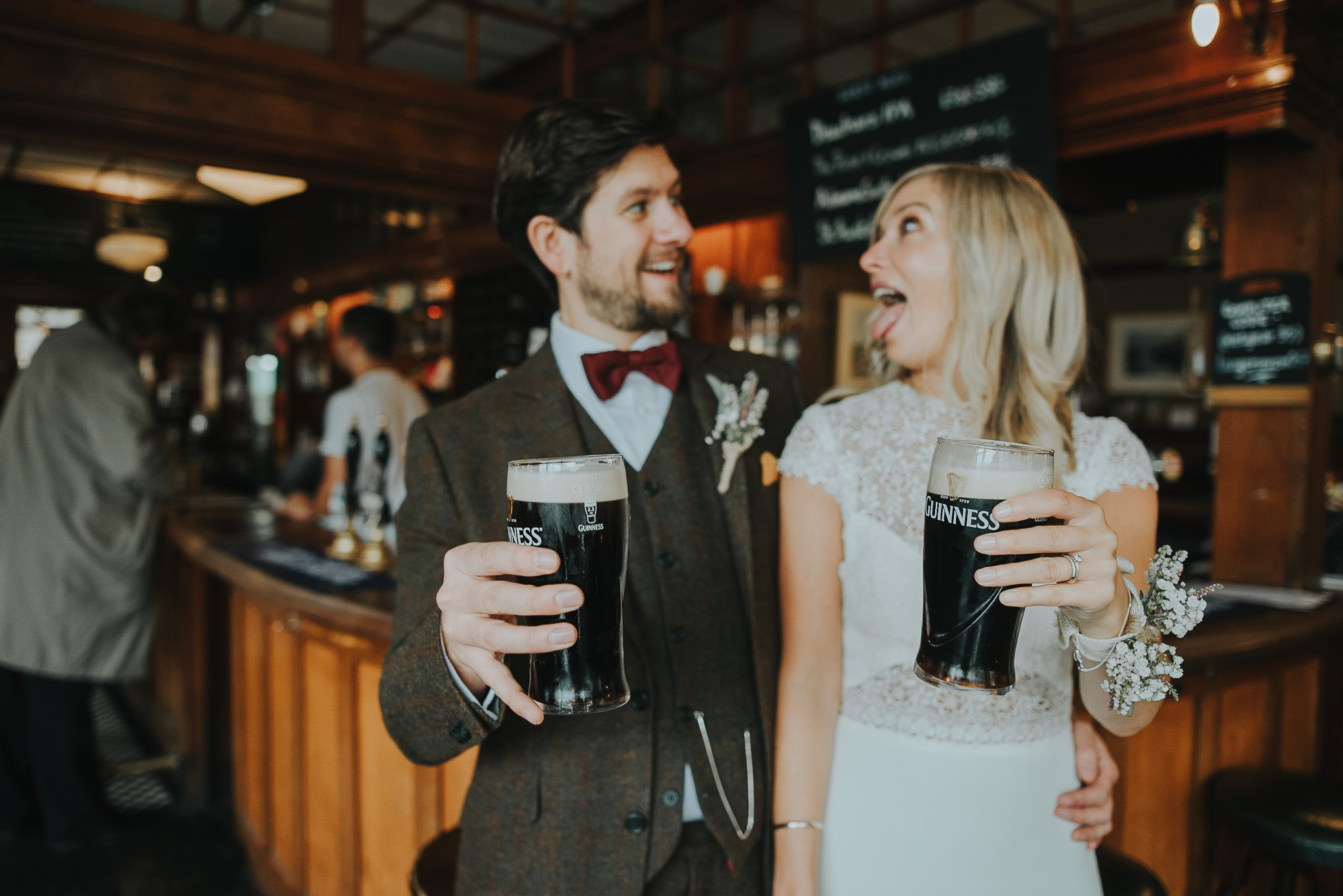 Bride and groom drink pints of Guinness in London pub The Rose and Crown after wedding