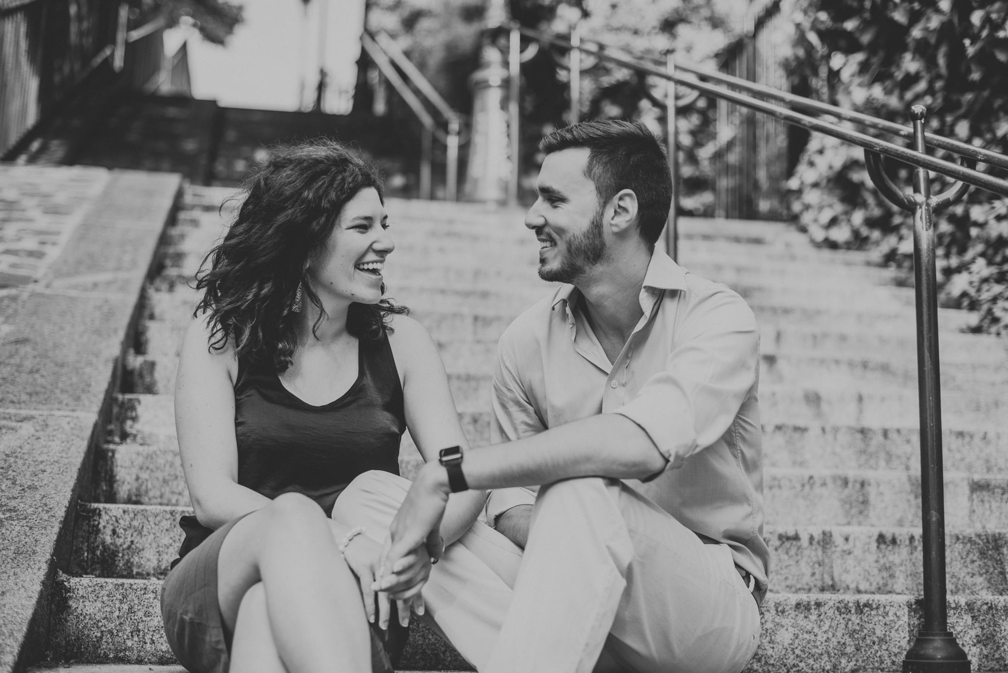 black and white image of man and woman in love sitting on steps in Montmartre, Paris