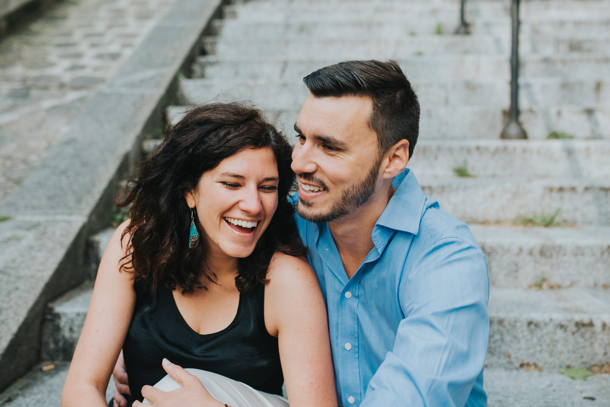 Close up of man and woman laughing on steps in Paris