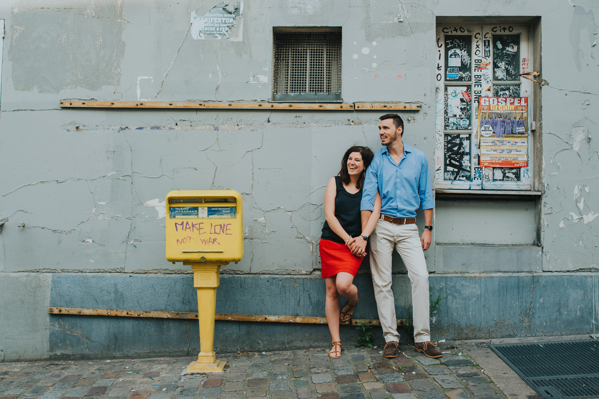 Paris pre-wedding photoshoot couple in love standing next to make love not war sign
