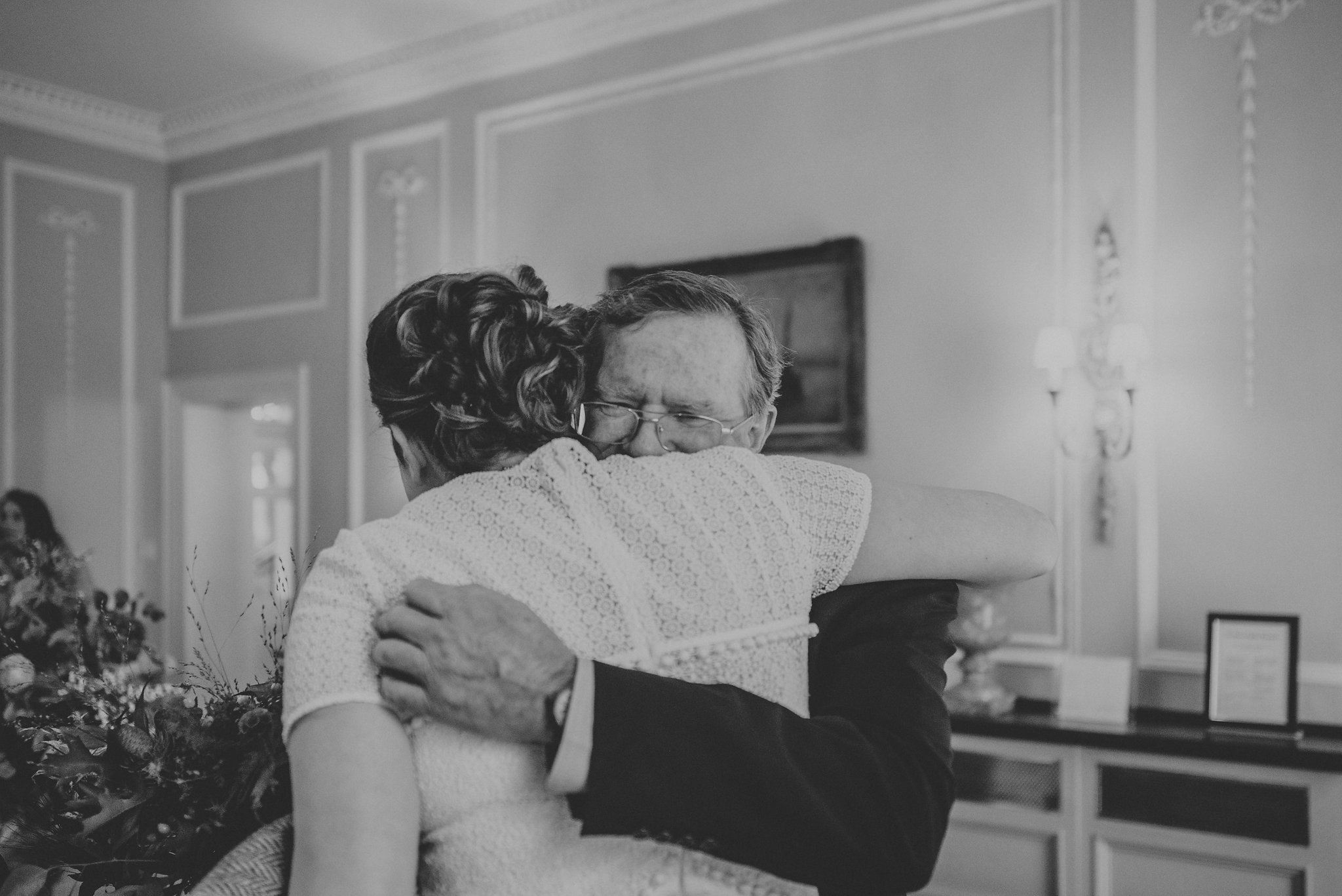 Bride being hugged by father on wedding day