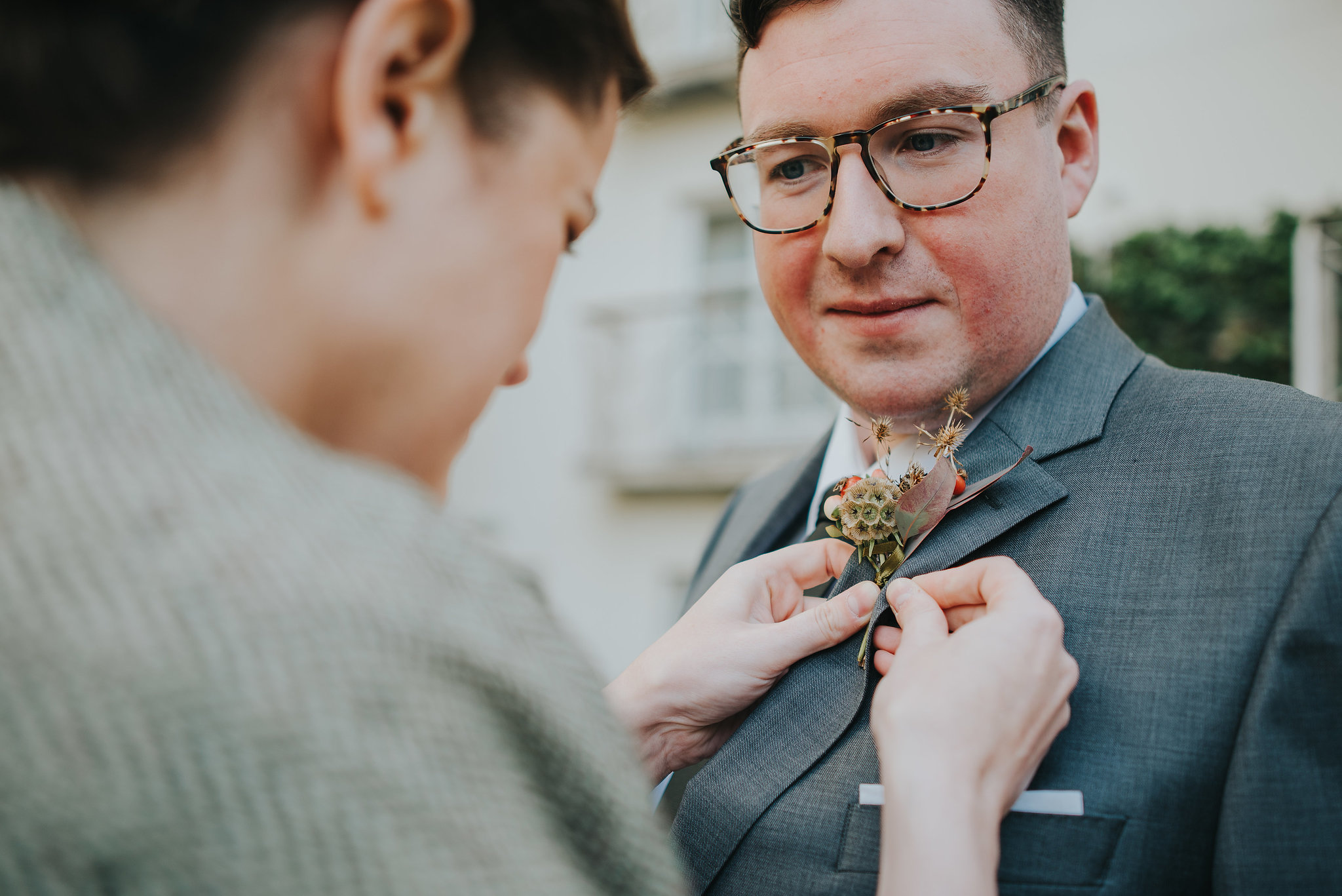 Bride fixing her groom's buttonhole on their wedding day