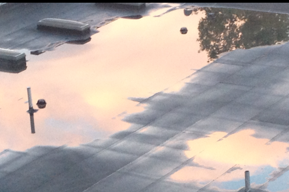 Puddle on roof reflecting the sky after the rain