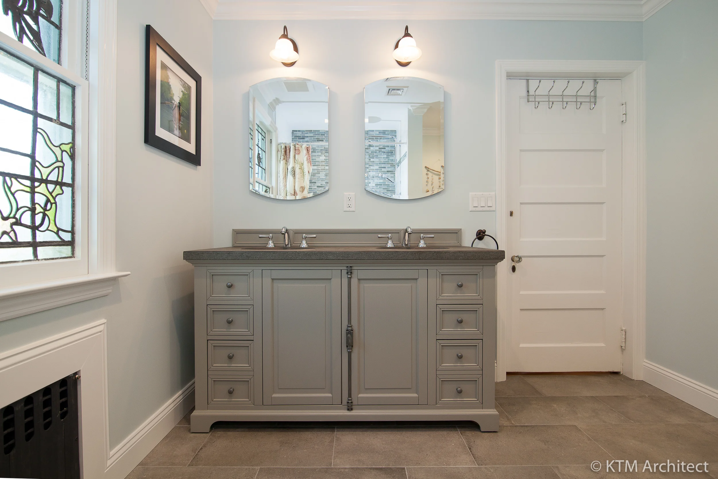 A well designed double vanity offers a range of storage options. As in the master, it has the feel of a freestanding piece of furniture and blends classic lines wit a contemporary grey color.