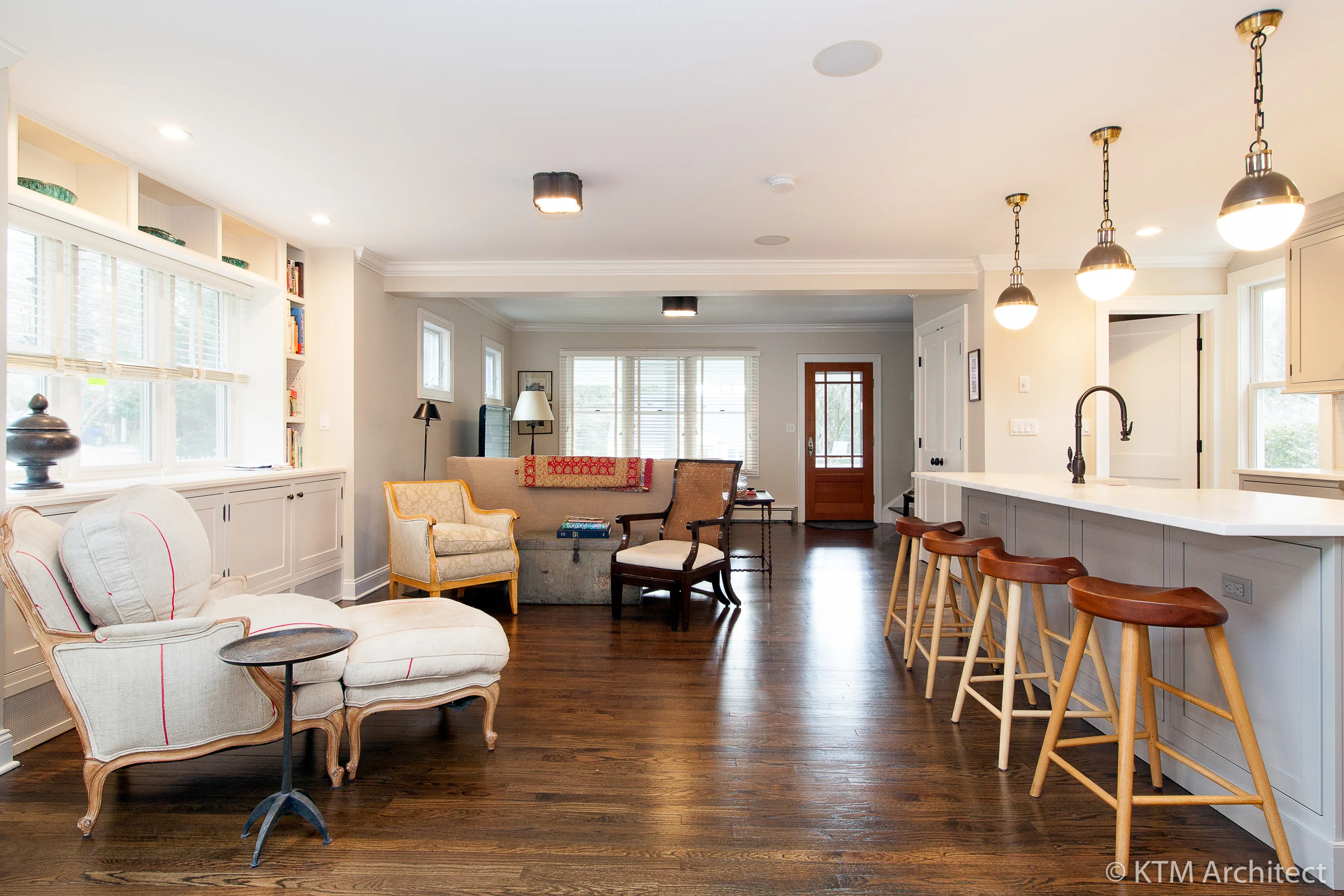 An informal seating area is adjacent to the island. Closer to the entry is an area for watching TV. Built ins and closets are in keeping with the shaker style of the kitchen.