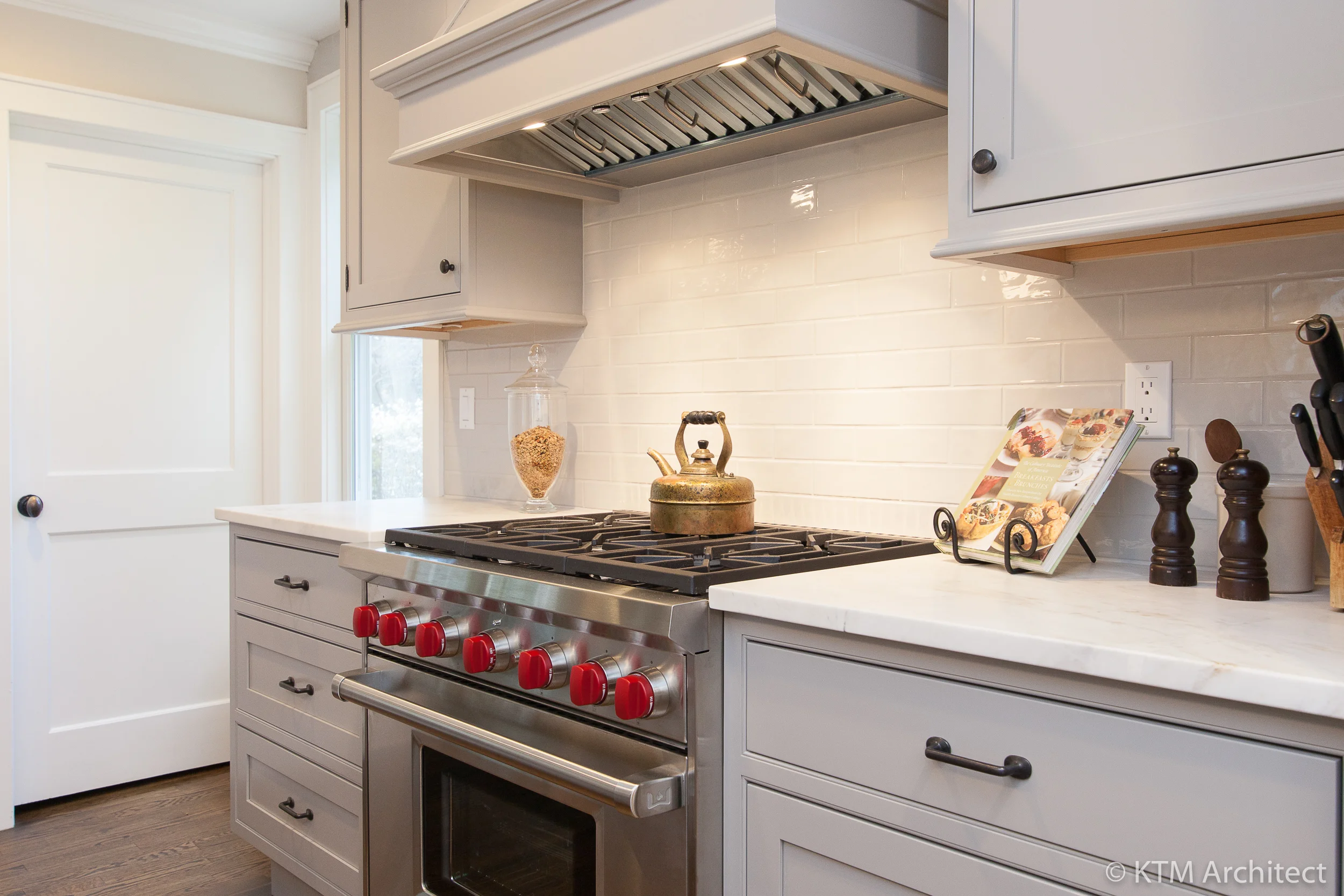 The Wolf range is flanked by marble prep areas and well constructed inset shaker cabinetry. A simple subway tile backsplash lets the cabinetry and range act as focal points.