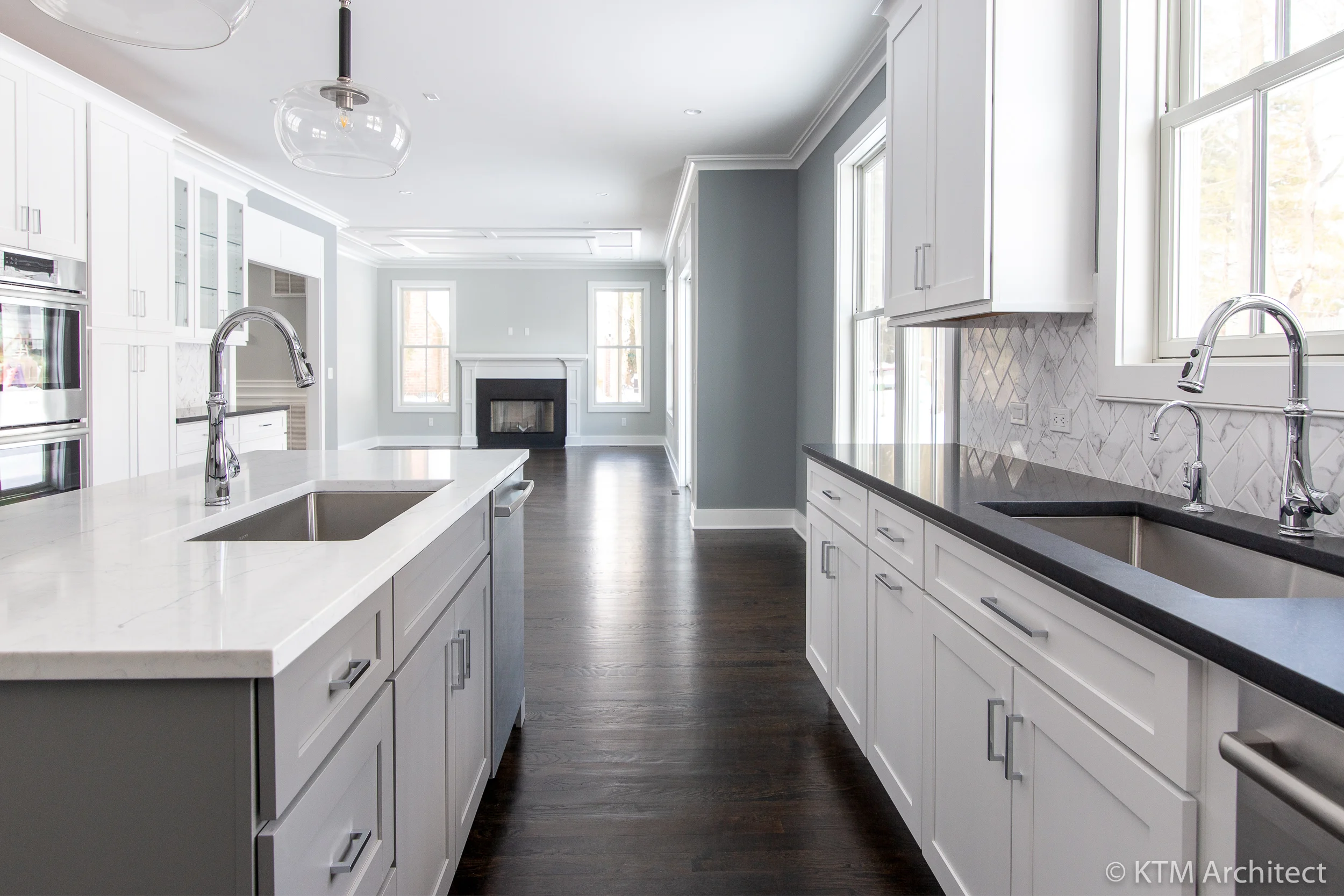 The true heart of this home is the open concept kitchen and living space. Once again we see a masterful interplay of light and dark with contrasting counters and countertops. The expansive room has high ceilings and large windows that bathe the room in light.