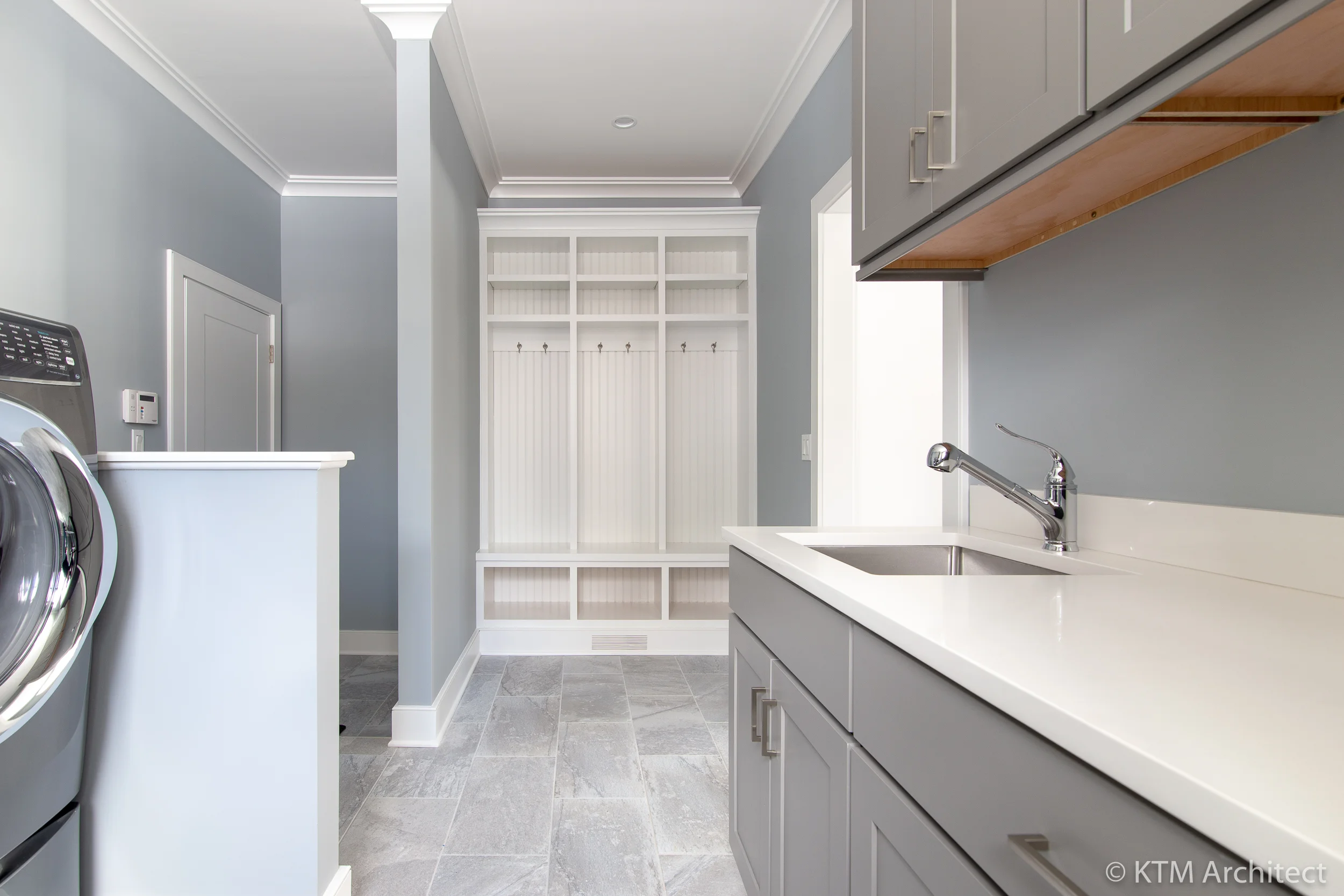 A built in open closet provides space for the family to shed shoes, backpacks, and jackets without cluttering the house. The garage door is pictured at left.