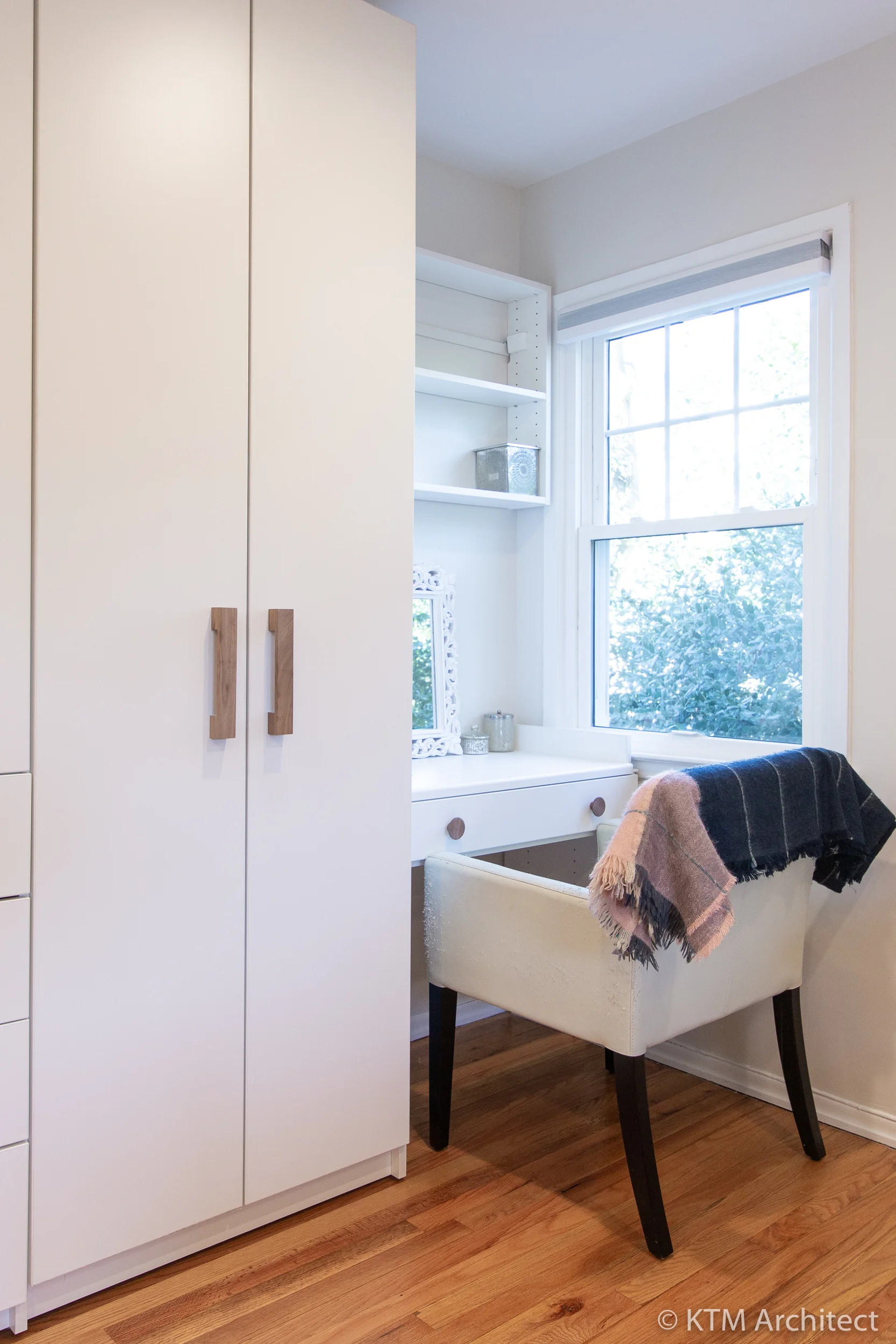 A simple desk area tucked away by the window performs many functions.