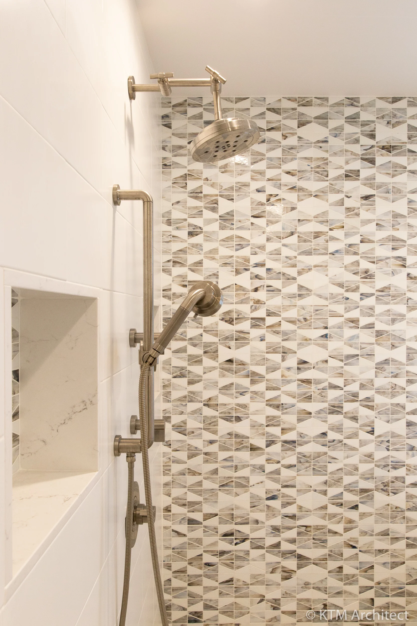 The shower includes niches to store items unobtrusively as well as a rain head and handheld fixtures.