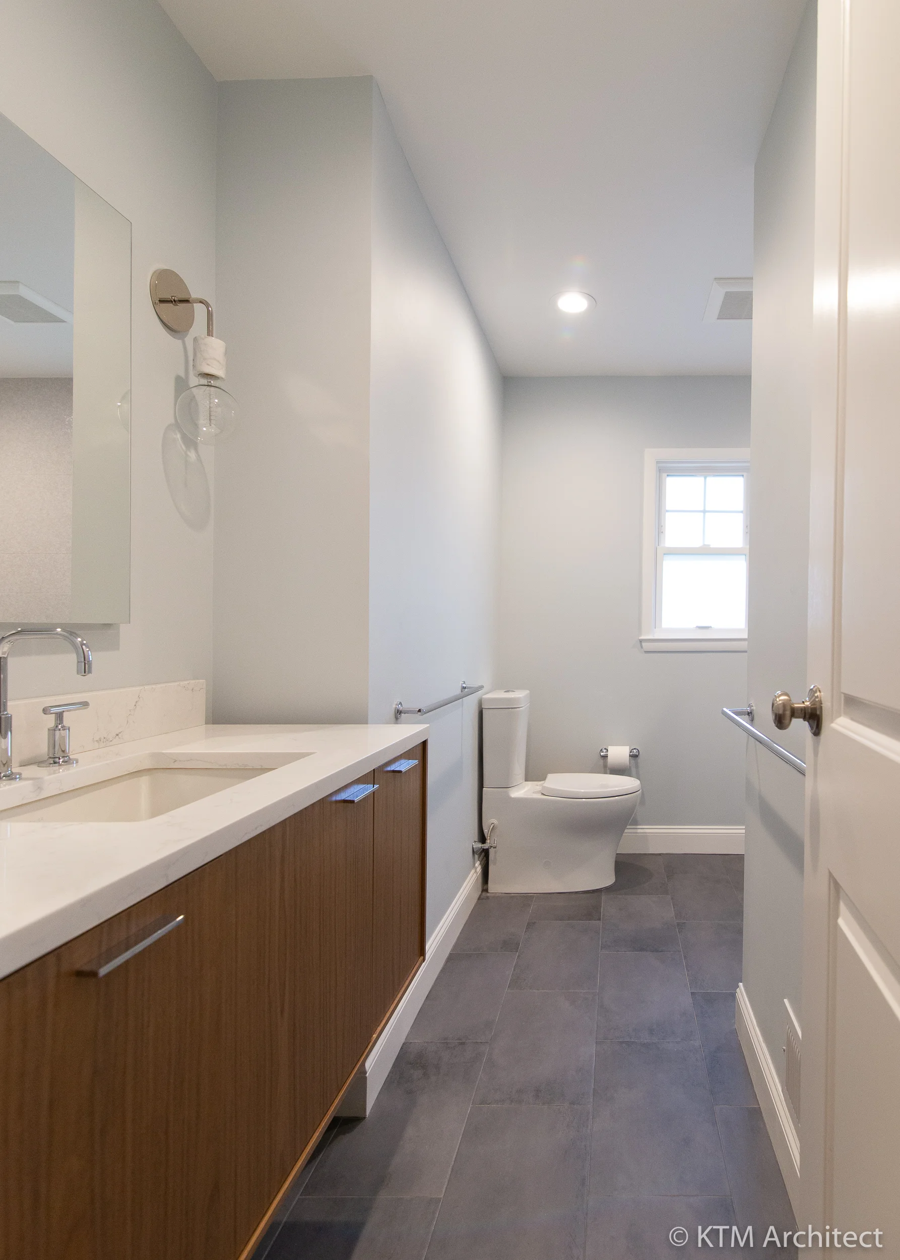 The tile floor is a natural grey hue that complements the soft blue walls.