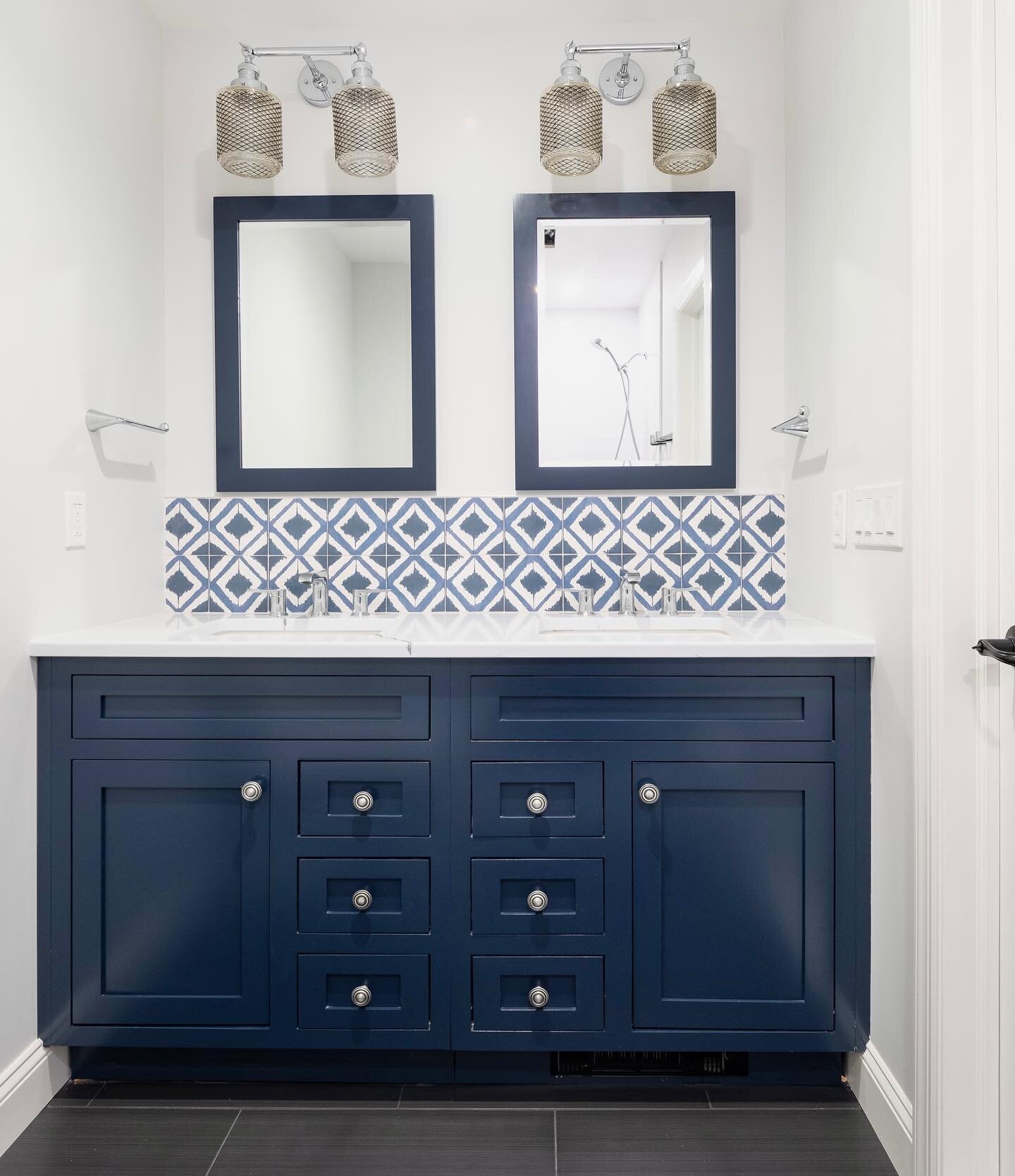 This smaller scale double vanity brings lots of function to this master bath. The patterned backsplash, elegant lighting and matching mirrors complete the ensemble. #smallspacedesign #bathroomdesign #bathroomremodel #bathroomdecor #blue #bluebathroom