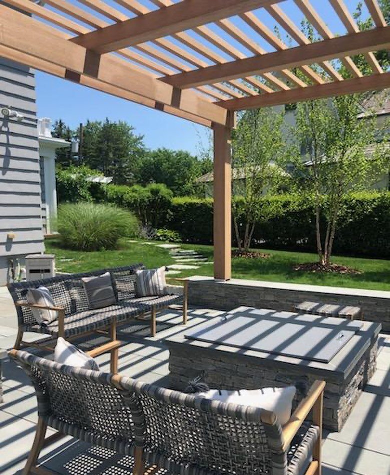 Just in time for summer: a bluestone patio with gas fire pit and seating area, framed in the shade of a mahogany pergola. A perfect way to make the backyard it&rsquo;s own destination!  #mahoganypergola #backyarddesign #patio #patiodesign #pergola #r