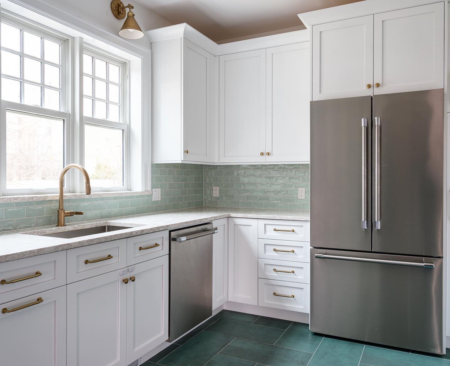 Simple and serene, this modern farmhouse kitchen features white shaker cabinets and a tea green backsplash. Honey bronze pulls by @topknobs as well as the @brizofaucet luxe gold faucet adds a graceful touch of luxury.  The clean lines of the Thermado