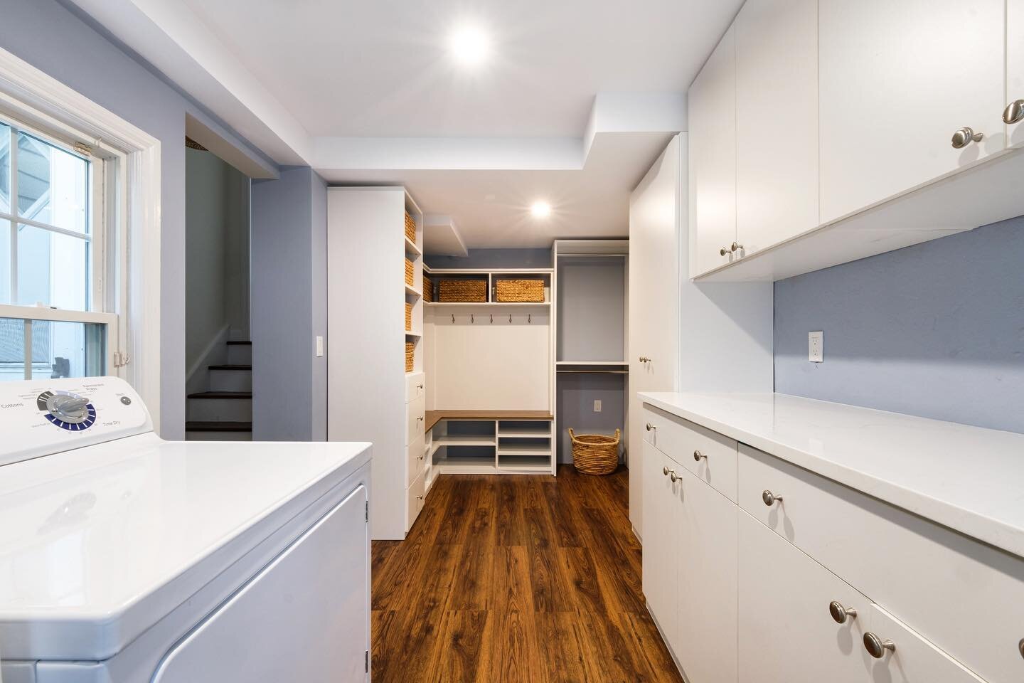 This relatively small space is filled with functionality. The laundry with built in storage and counter prep space is in the foreground, while a compact mudroom is at the rear, near the garage entrance. #smallspaces #laundry #mudroom #getorganized #s