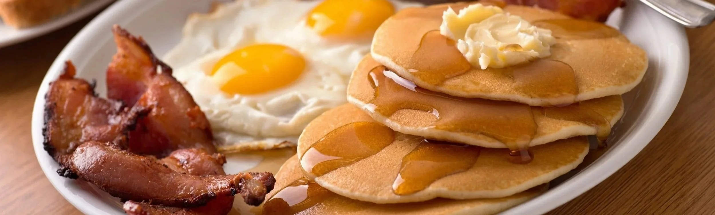 Pancakes, bacon, sunny side up eggs