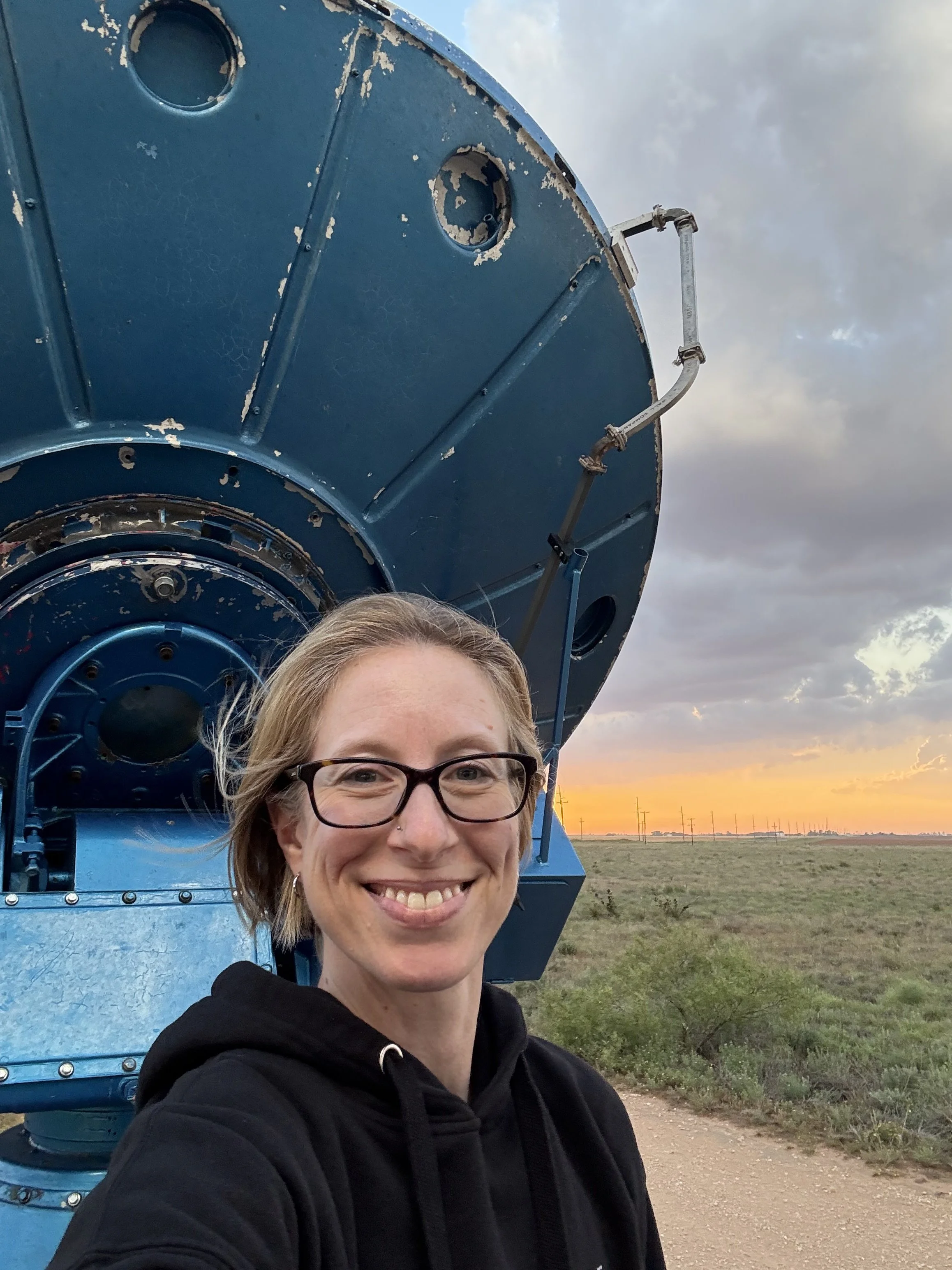 Jen in front of a mobile radar antenna