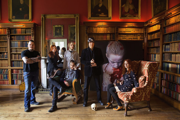 The artist Gottfried Helnwein with his wife, Renate, and their four children, from left, Cyril, Wolfgang Amadeus, Ali (sitting) and Mercedes in the library of the 19th-century Gurteen Castle. In the background, a painting from Gottfried’s “The Disasters of War” series 2014, Kenneth O Halloran