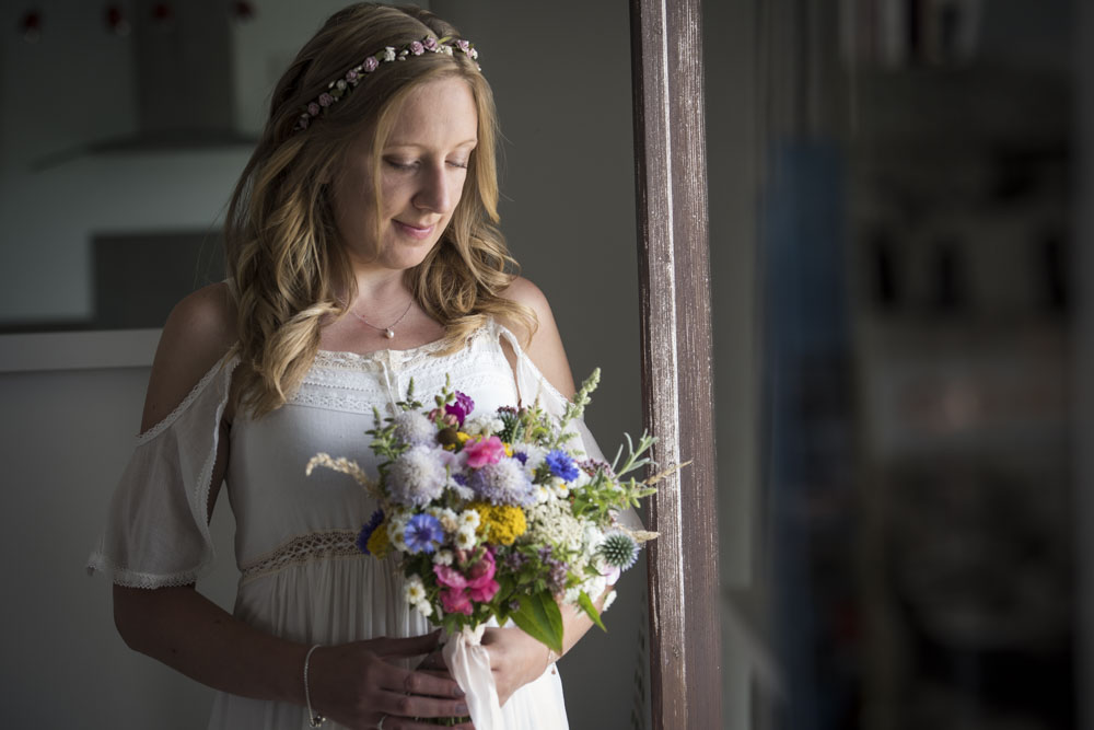 Bride with window light and bouquet at boho cornwall.jpg