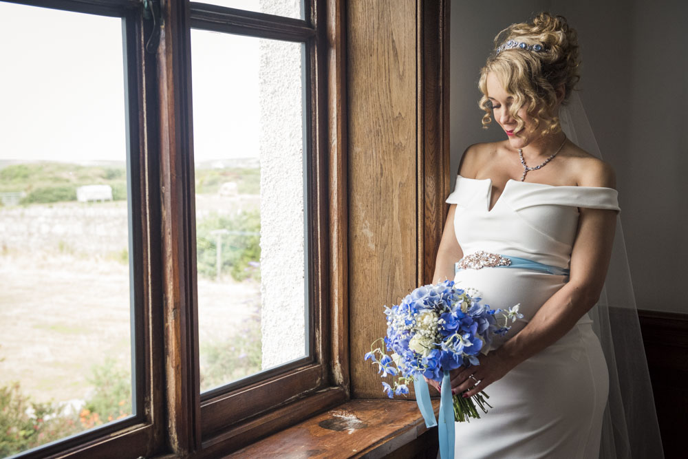 bride with flowers by window boho cornwall.jpg