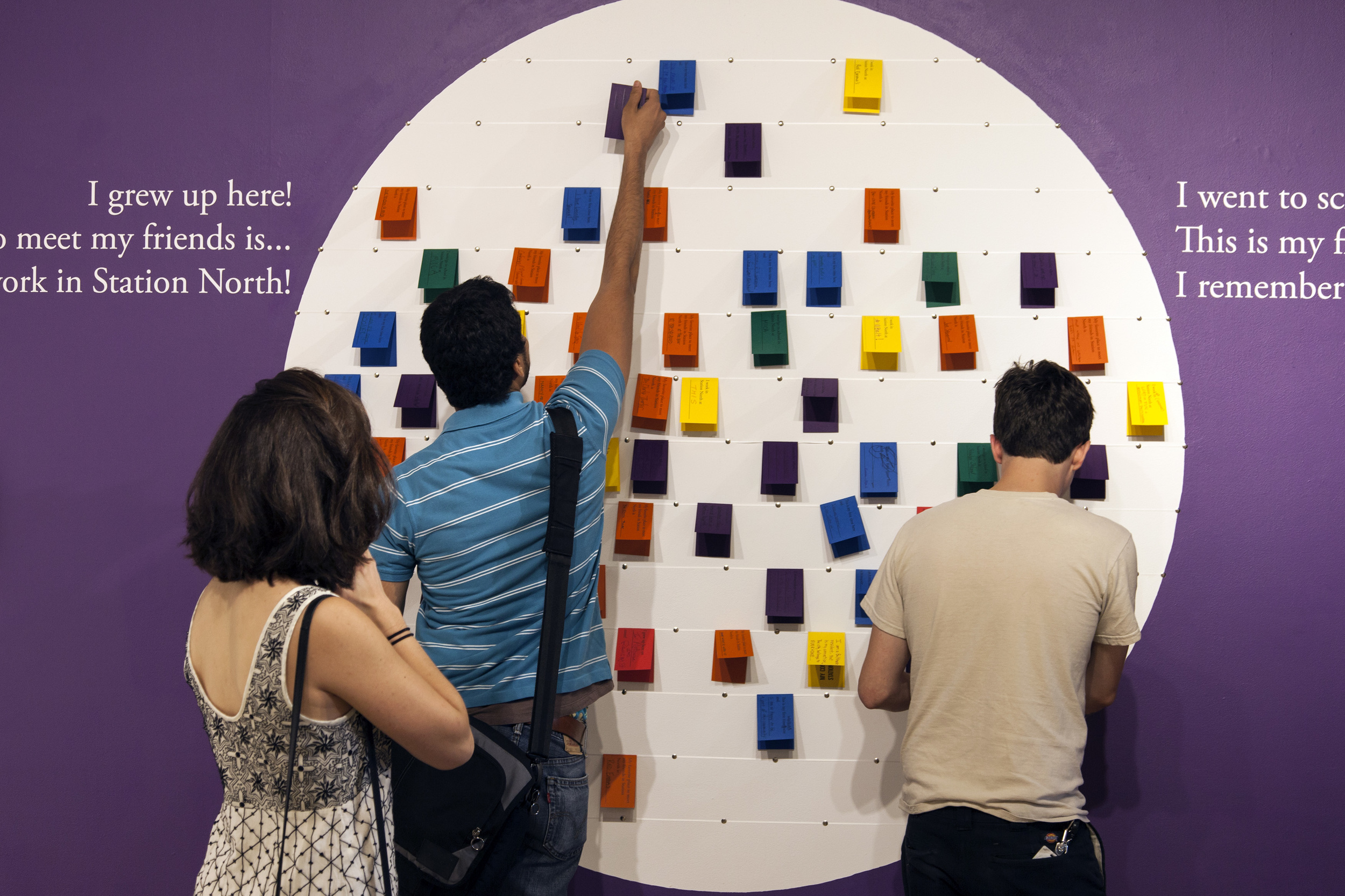 Visitors contributing to the interactive wall asking about their associations to the neighborhood. Click to view more photos from the opening reception.