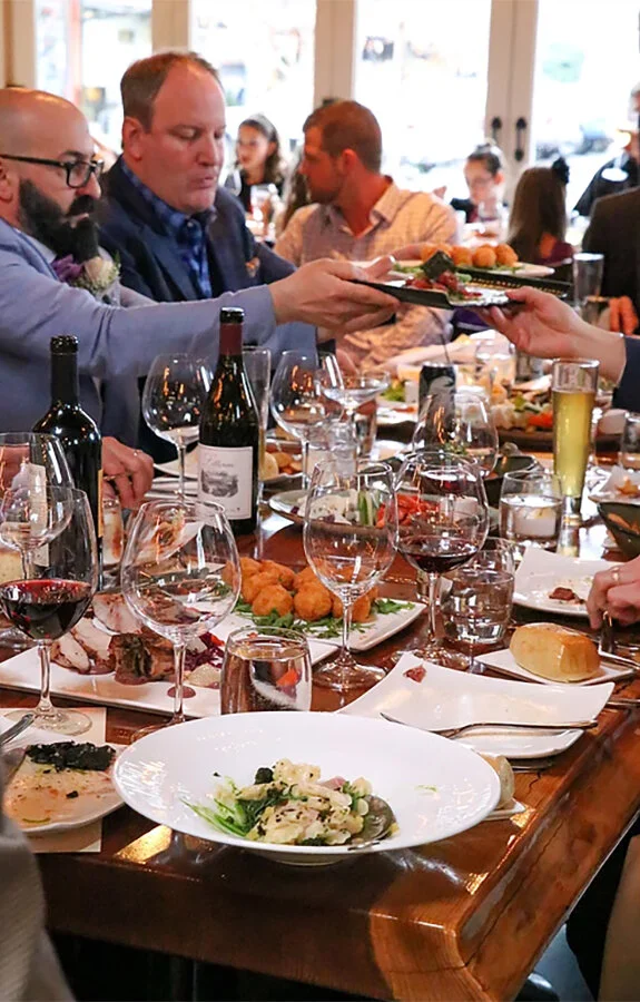 Guests dining at Valette Restaurant with wine and shared plates