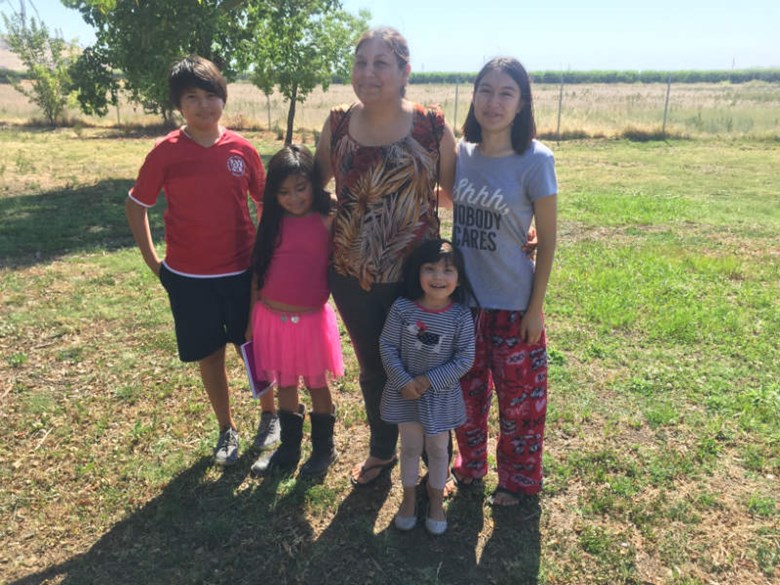 Claudia Angulo stands with her four children outside their home in Orange Cove, California. Angulo says her son Isaac was exposed to toxic levels of the pesticide chlorpyrifos while she was pregnant with him. Ali Budner / Capital Public Radio