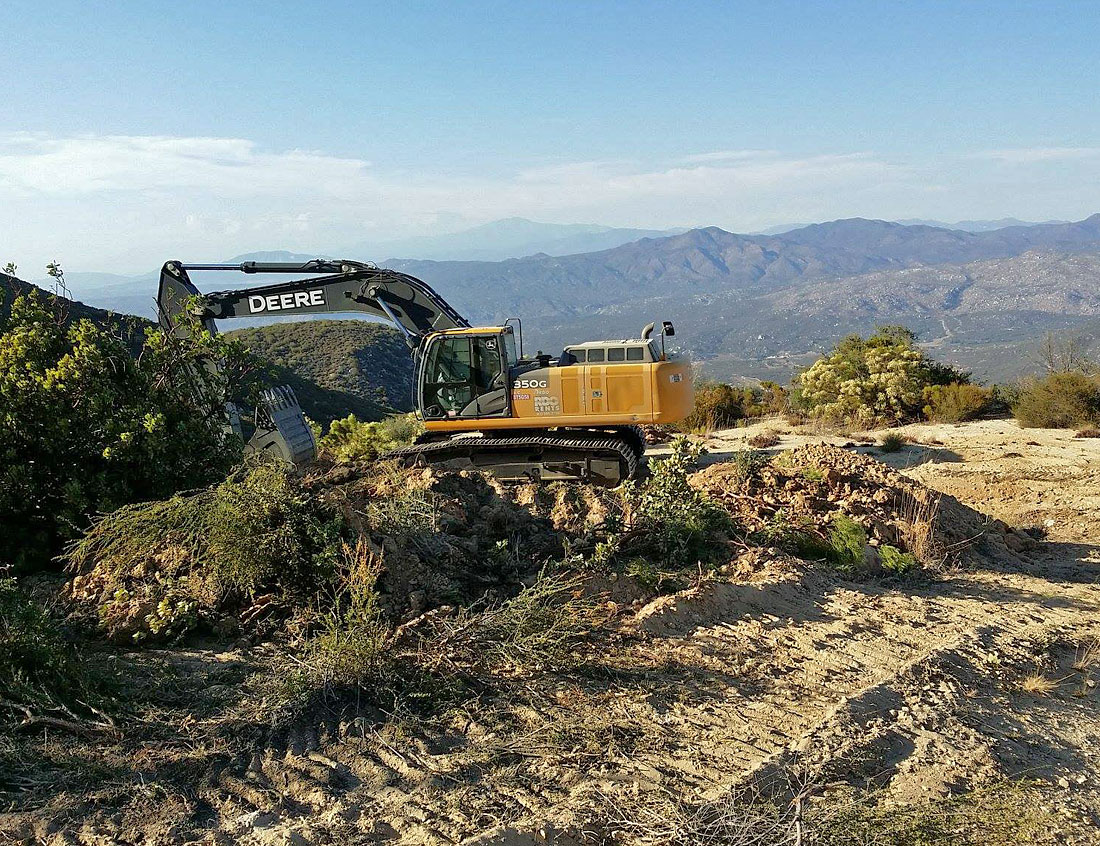 The Deere clears out brush in preparation for the pegmatite exposure. Click to enlarge. (Photo: Casey Jones) 