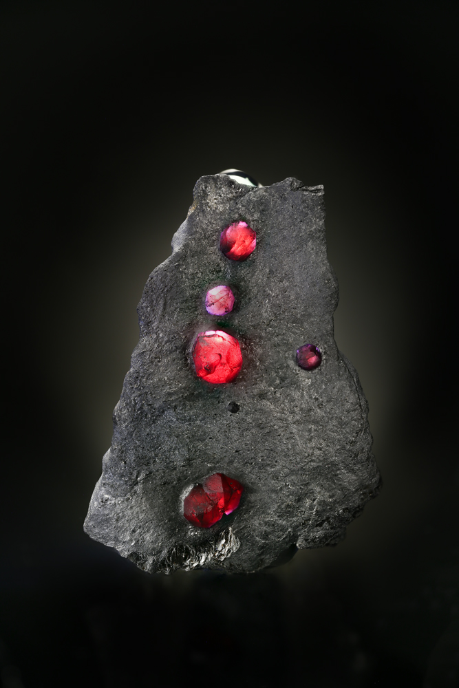 Red embers. A gorgeous example of pyrope garnets in schist, from the Red Embers Mine in Erving, Massachusetts. Read the story behind this specimen at the tail end of " Appraising Harvard Redux ." (Photo: Ben DeCamp)