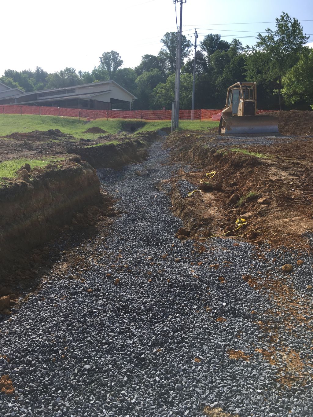 Electrical conduit trench filled with stone, conduits turning up pole.jpg