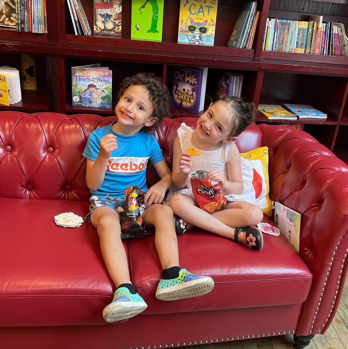 Happiness is a red couch in a bookshop - brother and sister enjoying time at @bluebunnybooks in @dedhamsquare 💙