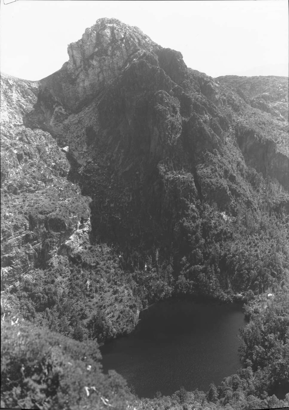 Frank Hurley's photo of Lake Tahune in 1947. Lions Head towers above the lake while the face of Frenchmans Cap is to the left of this scene. Source: National Library of Australia .