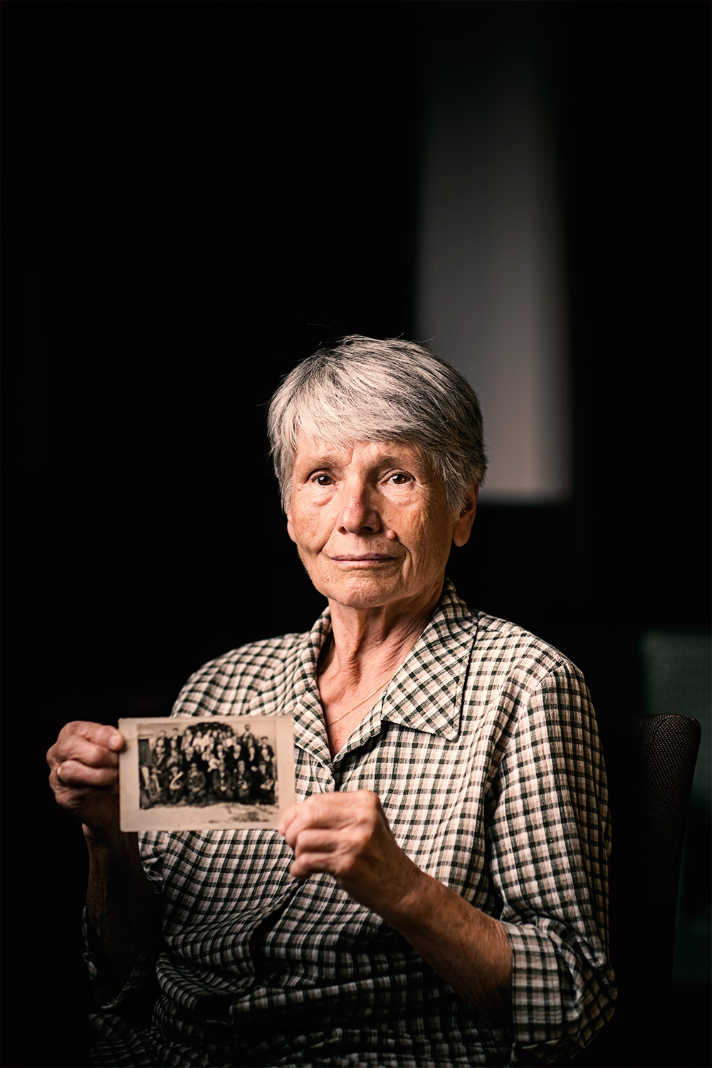Portrait einer alten Frau mit einem Erinnerungsfoto in Händen