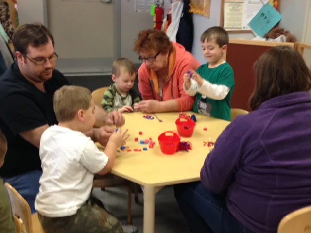 Children and family sitting around the table doing activities