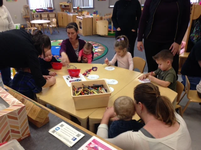 Children and families sitting around the table coloring