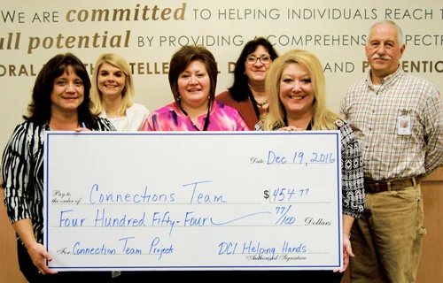 Photo of employees and check presentation.