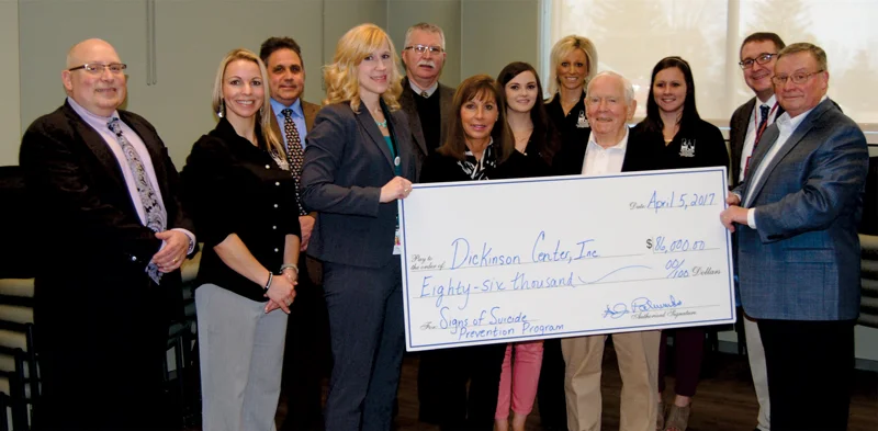 Photo of DCI Leadership and Signs of Suicide staff receiving a check for $86,000 from AJ & Sigismunda Palumbo Charitable Trust members.