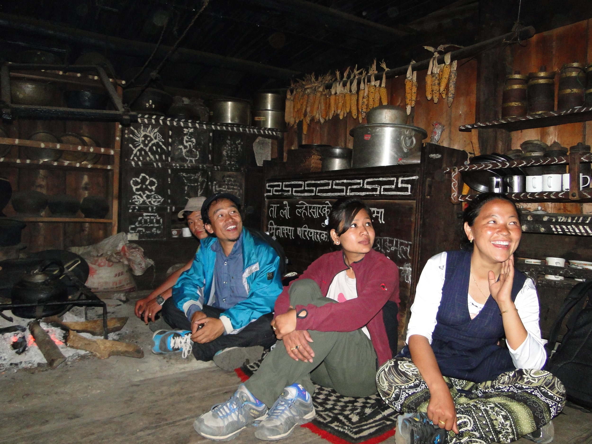 Chepuwa, Sankhuwasabha, 2016: A family sit round a traditional open hearth. Such fires result in high levels of smoke indoors, the roof is black is soot. Wood also burns quickly on an open fire, this means large quantities of wood need to be harvested, collected and stored. An environmentally damaging and time consuming process. 