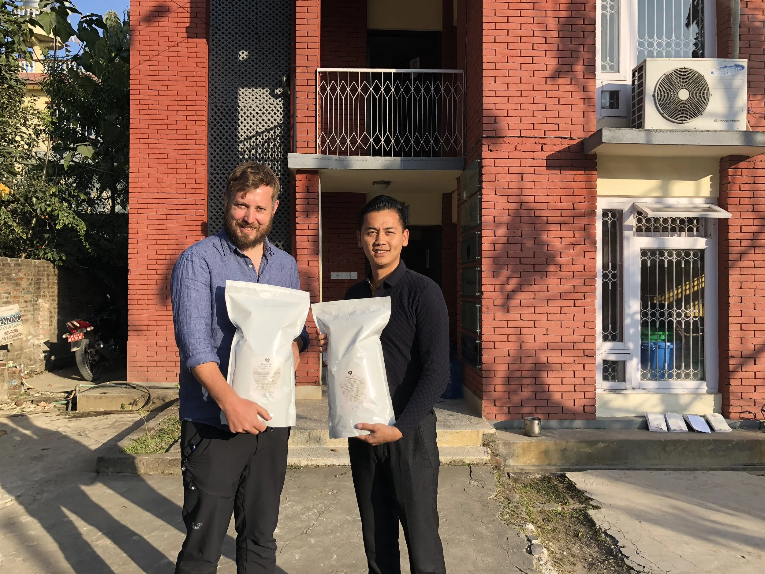 Appa Sherpa, head of Nuwa Coffee Estate, hands over the roasted beans to Dr Morgan Phillips, TGT Co-Director in Kathmandu.