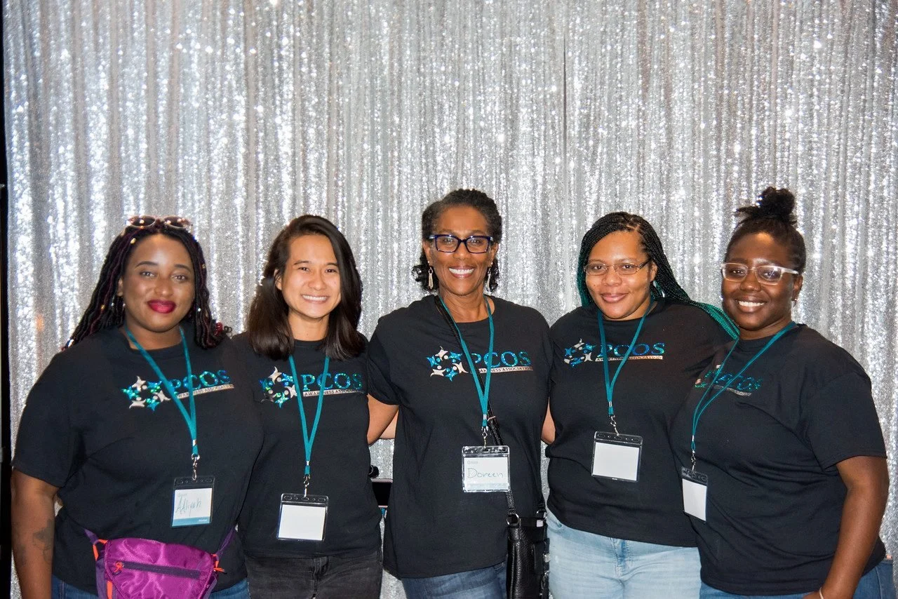 Five smiling women in PCOS Awareness Association shirts and lanyards at PCOS CON 2019
