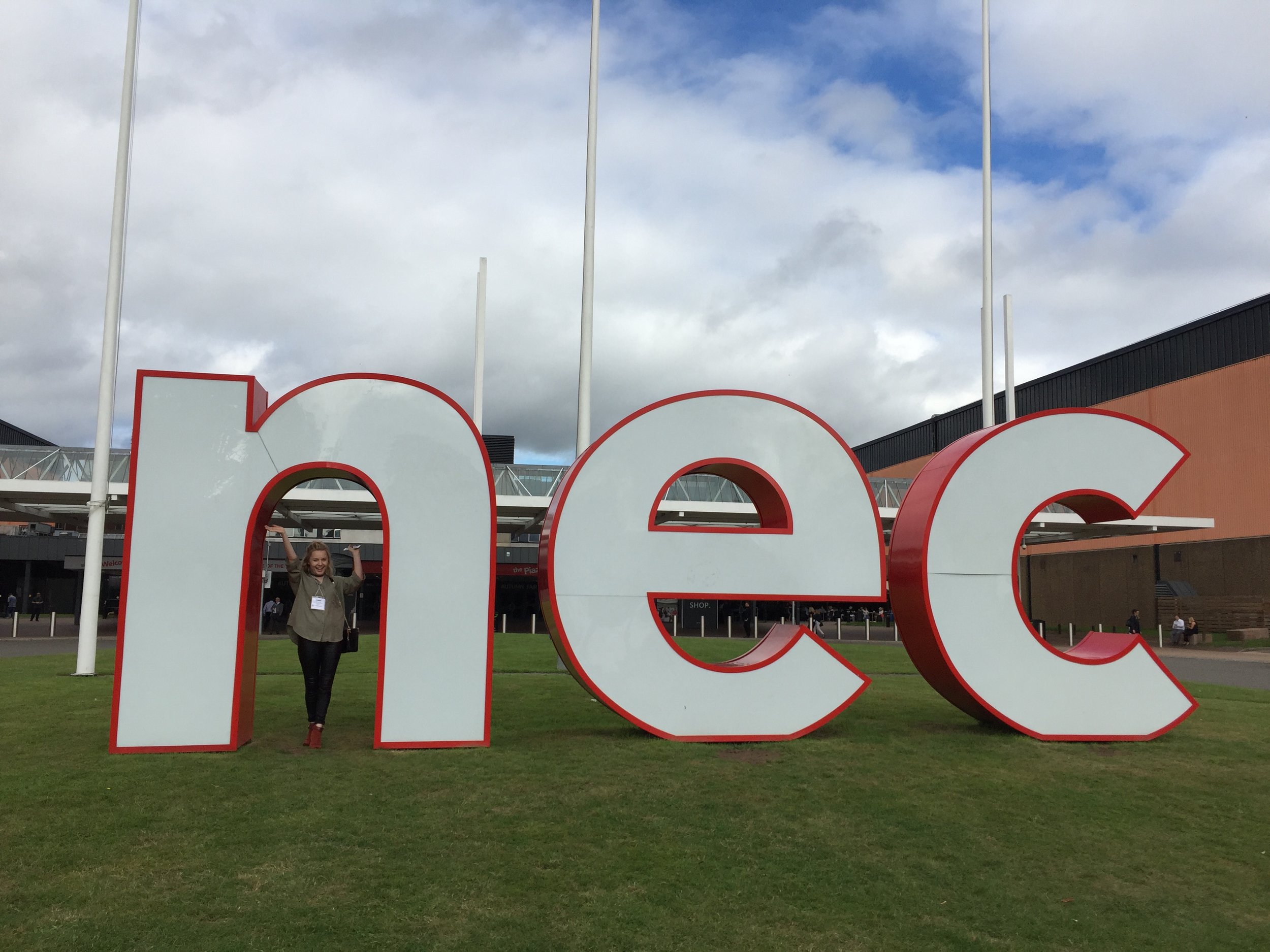 Rebecca with the NEC sign.