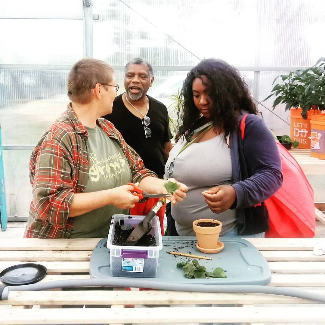 Farmer Laurie helping Neighbors plant herbs.