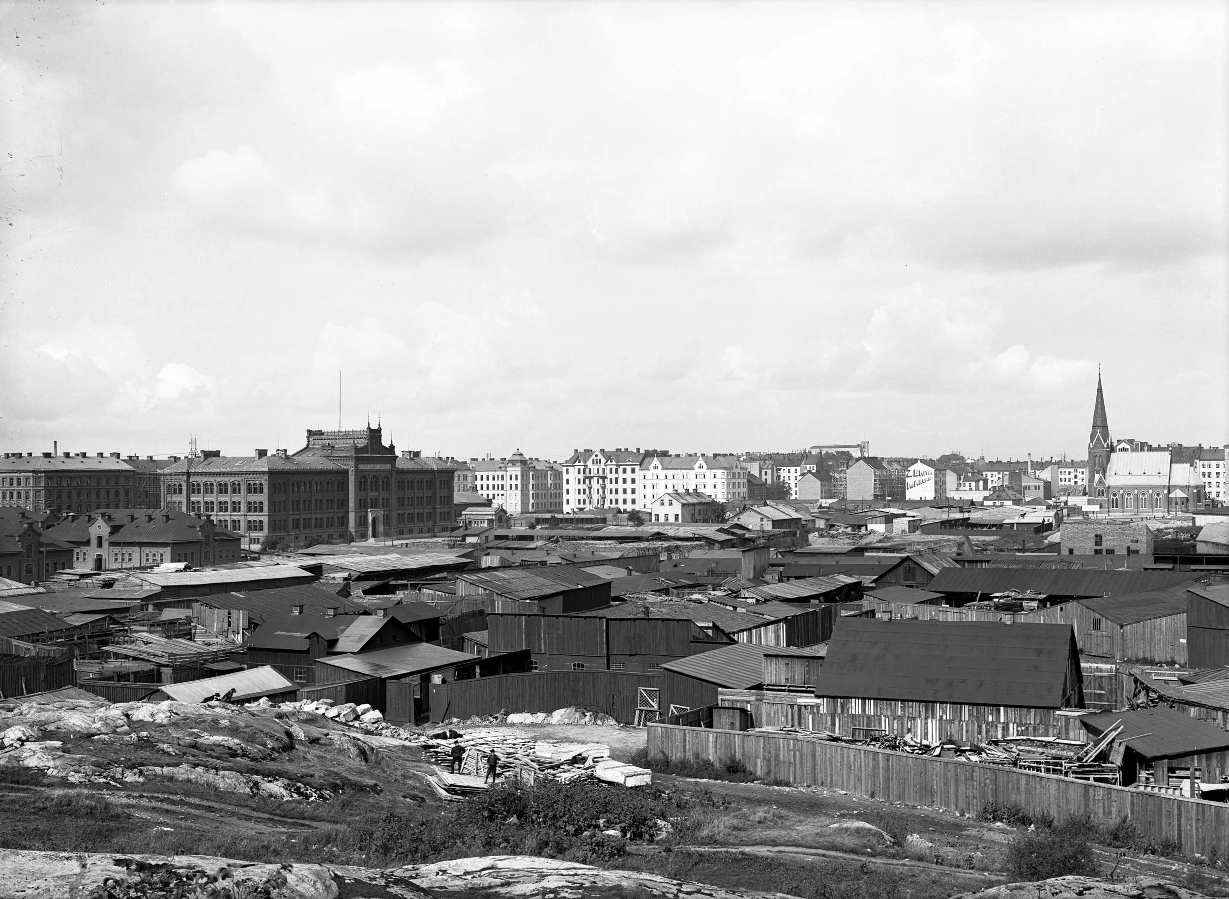Träskängsfotot. Norra Real byggdes intill en dåvarande kåkstad i Träskängen, nuvarande Jarlaplan, i Stockholm. Kommunen drev på planeringen genom uppförandet av det nya Läroverket, som när det byggdes ansågs progressivt både i fråga om pedagogik och skollokaler. Foto: Oscar Heimer, Stockholms stadsmuseum, 1909